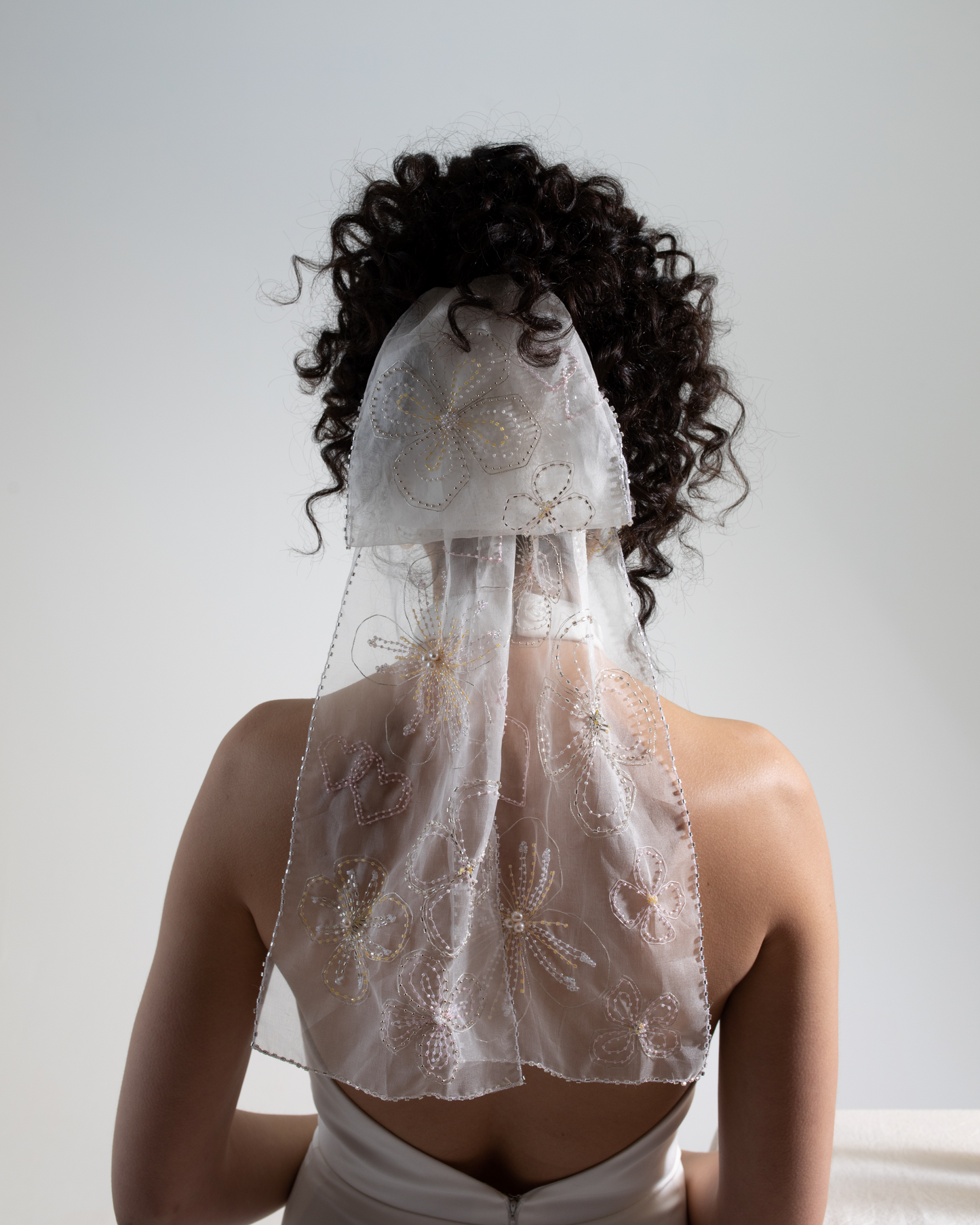 Hand embellished silk organza bow veil.  A bridal bow hand-embroidered in a floral design as part of a collection of luxury decorative bridal accessories and bridal headwear.