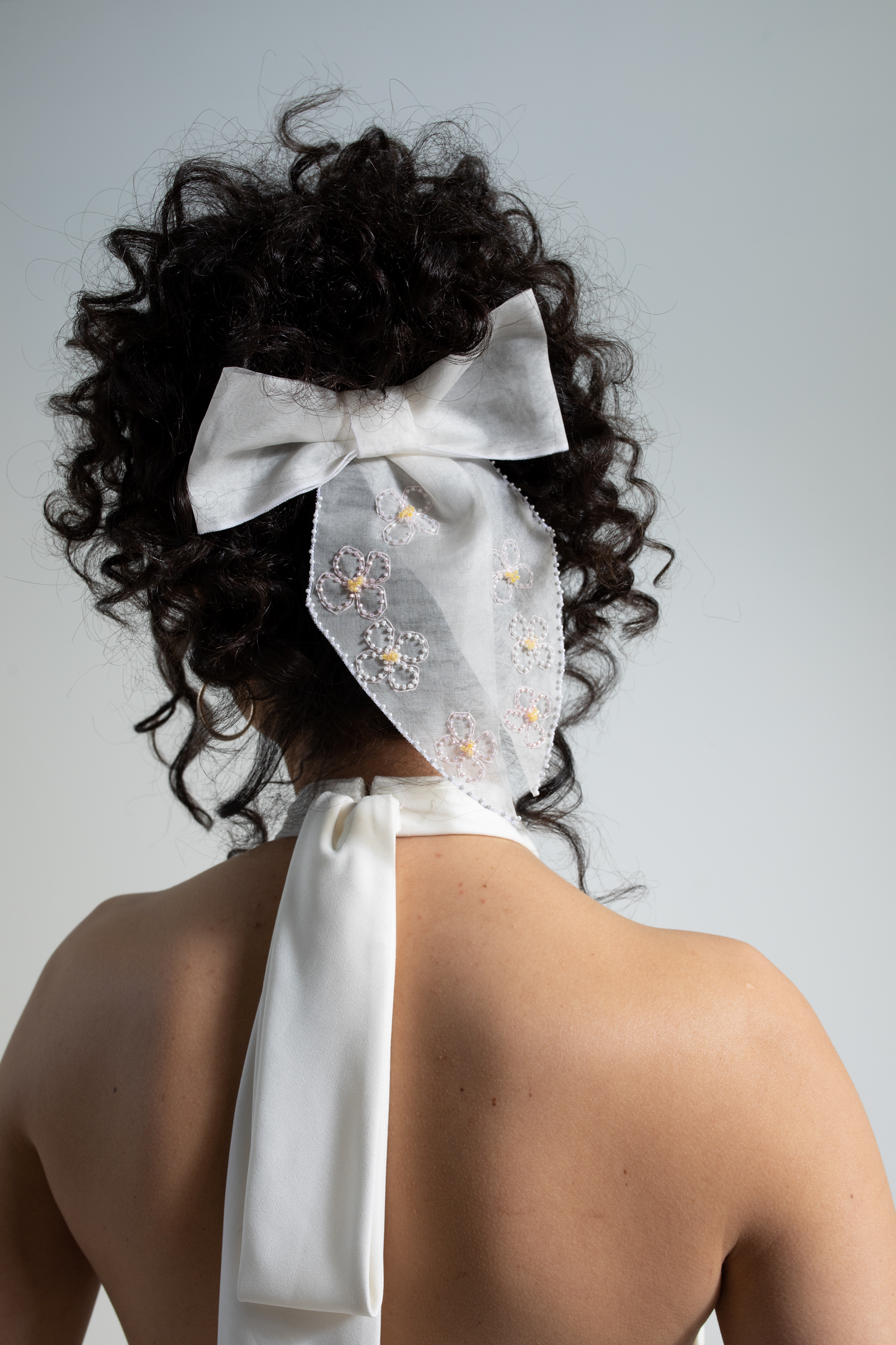 Silk organza bridal bow, delicately hand-embroidered with beaded blossom flowers. This decorative hair bow is part of a collection of embellished luxury bridal accessories and bridal headwear.