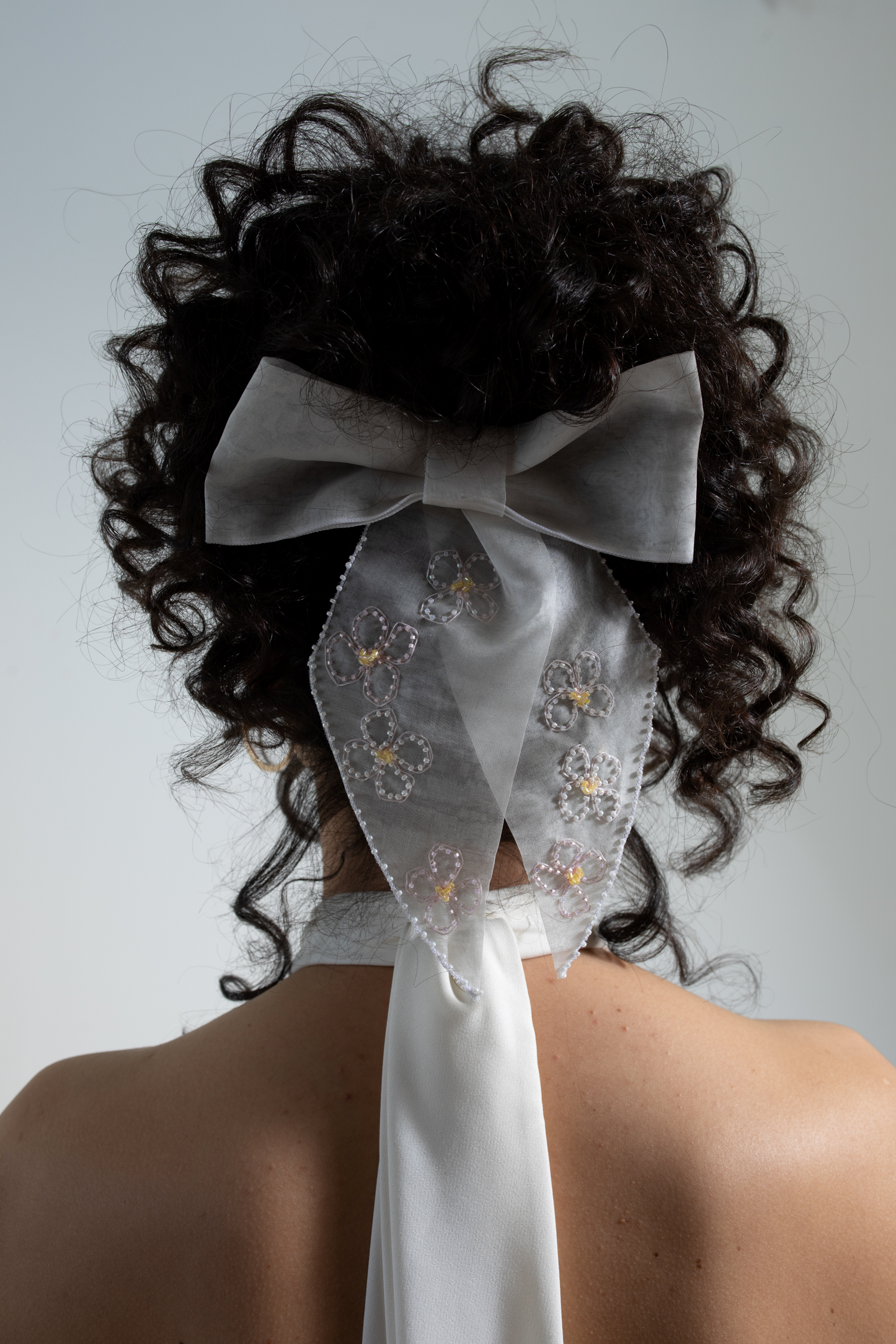 Silk organza bridal bow, delicately hand-embroidered with beaded blossom flowers.  This decorative hair bow is part of a collection of embellished luxury bridal accessories and bridal headwear.