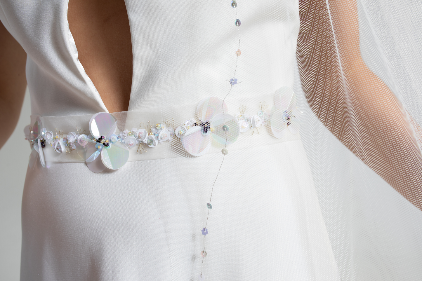 Hand-embroidered silk organza wedding belt decorated with hand-sewn sequins and beads in a floral design. This embellished bridal belt is part of a collection of luxury hand-made bridal accessories.